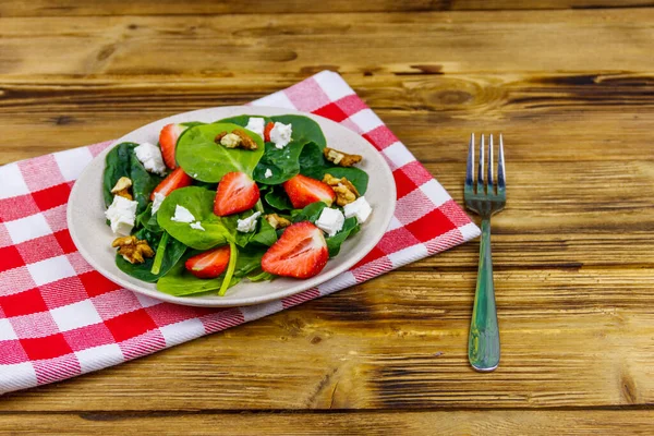 Tahta masada çilekli, ıspanaklı, cevizli ve peynirli taze sağlıklı salata.