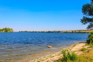 Güzel bir nehir, yeşil ağaçlar ve mavi gökyüzü olan yaz manzarası