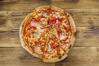 Tahta bir masada nefis taze pizza. Üst görünüm