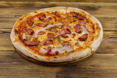 Ahşap bir masada sosisli, mantarlı ve peynirli lezzetli taze pizza.