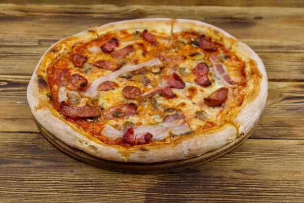 Ahşap bir masada sosisli, mantarlı ve peynirli lezzetli taze pizza.