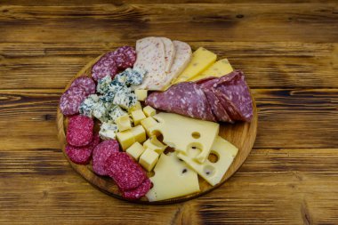 Tahta masada İtalyan salam ve peynirinden oluşan antipasti tabağı.