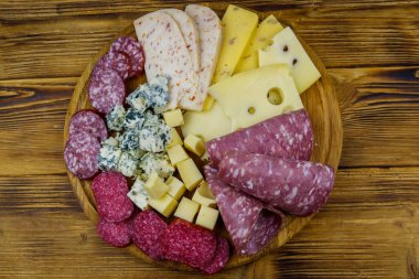Tahta masada İtalyan salam ve peynirinden oluşan antipasti tabağı. Üst görünüm