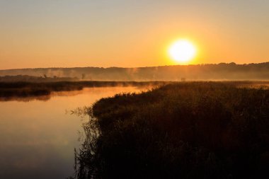 Gün doğumunda sisli nehir manzarası. Sabaha karşı sisli