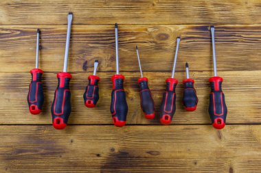 Tahta arka planda bir tornavida seti. Üst görünüm