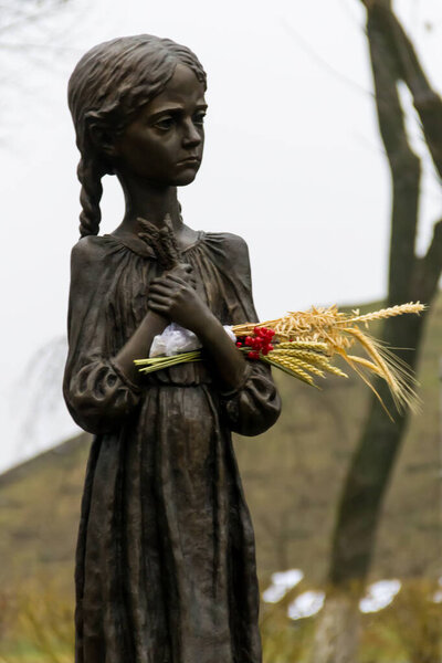 Fragment of The National Museum "Holodomor victims Memorial". Sculpture of hungry young girl with ears of wheat in their hands. Kiev, Ukraine