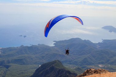 Türkiye 'nin Antalya ilinin Kemer ilçesi yakınlarındaki Tahtali dağının tepesinden paraşütçüler uçuyor. Aktif yaşam tarzı ve ekstrem spor macerası kavramı