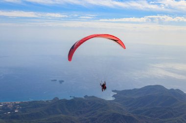 Türkiye 'nin Antalya ilinin Kemer ilçesi yakınlarındaki Tahtali dağının tepesinden paraşütçüler uçuyor. Aktif yaşam tarzı ve ekstrem spor macerası kavramı
