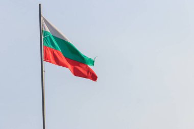 Mavi gökyüzüne dalgalanan Bulgaristan bayrağı