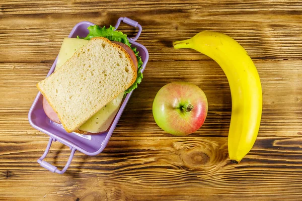 Sandviç, muz ve elmayla dolu bir beslenme çantası. Üst görünüm