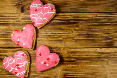 Tahta masada kalp şeklinde kurabiyeler. Üst görünüm, boşluğu kopyala. Sevgililer Günü için tatlı.