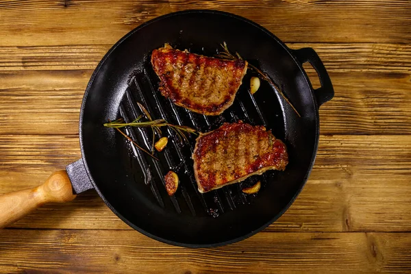 돼지고기 스테이크에 로즈마리 향신료를 무쇠그릴 프라이팬을 던진다 위에서 — 스톡 사진