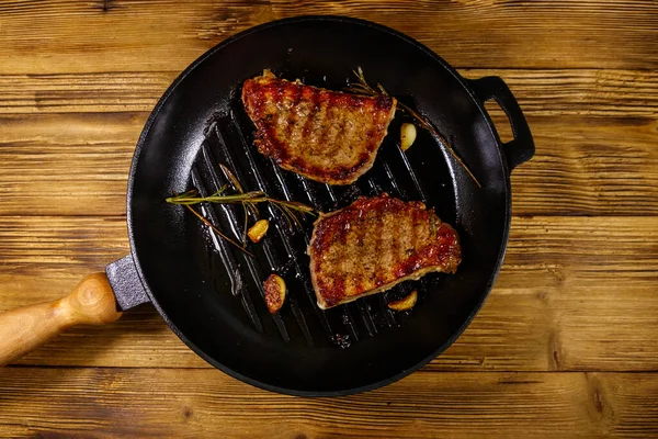 Grillade Fläskbiffar Med Rosmarin Vitlök Och Kryddor Stekpanna Gjutjärn Träbord — Stockfoto