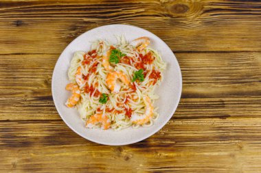 Karidesli spagetti makarna, domates sosu ve ahşap masada maydanoz. Üst görünüm