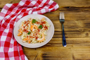 Karidesli makarna, domates sosu ve ahşap masada maydanoz.