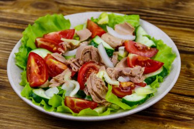 Marullu lezzetli ton balığı salatası ve ahşap masada taze sebzeler.