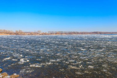 Baharda eriyen buzla kaplı bir göl manzarası