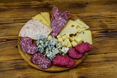 Tahta masada İtalyan salam ve peynirinden oluşan antipasti tabağı.