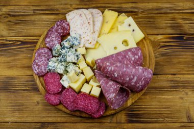 Tahta masada İtalyan salam ve peynirinden oluşan antipasti tabağı. Üst görünüm