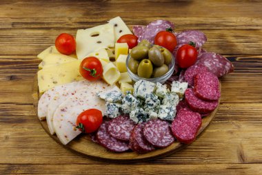Zeytinli, kiraz domatesli, ahşap bir masada İtalyan salamı ve peyniri karışımı.