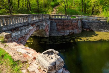 Ukrayna 'nın Kharkov bölgesindeki Sharovka Sarayı parkındaki bir gölette eski kemerli tuğla köprü.