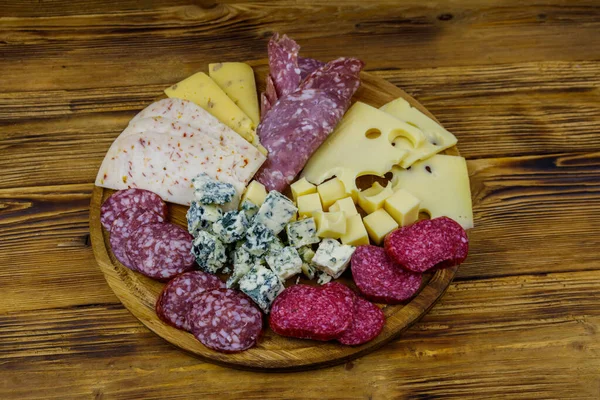Tahta masada İtalyan salam ve peynirinden oluşan antipasti tabağı.