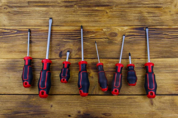 Tahta arka planda bir tornavida seti. Üst görünüm