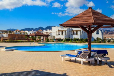 Yüzme havuzunun yanında şezlonglar. Spa, dinlenme, rahatlama, tatil, tatil