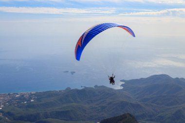 Türkiye 'nin Antalya ilinin Kemer ilçesi yakınlarındaki Tahtali dağının tepesinden paraşütçüler uçuyor. Aktif yaşam tarzı ve ekstrem spor macerası kavramı