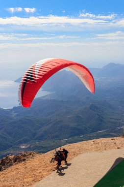 Türkiye 'nin Antalya ilinin Kemer ilçesi yakınlarındaki Tahtali dağının tepesinden paraşütçüler uçuyor. Aktif yaşam tarzı ve ekstrem spor macerası kavramı