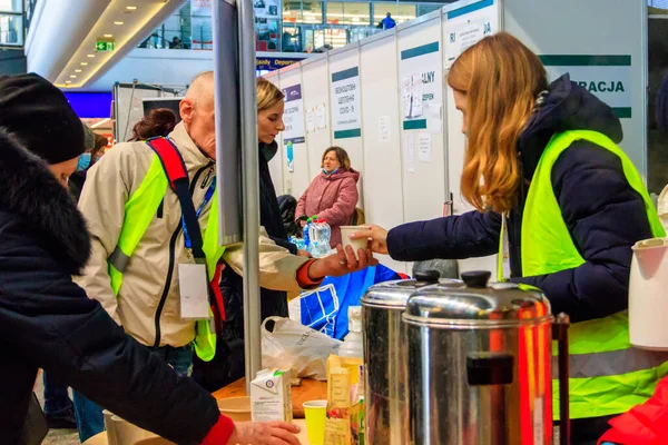 Varşova, Polonya - 9 Mart 2022: Gönüllüler Polonya 'nın Varşova kentindeki tren istasyonunda Ukraynalı mültecilere yardım ediyor