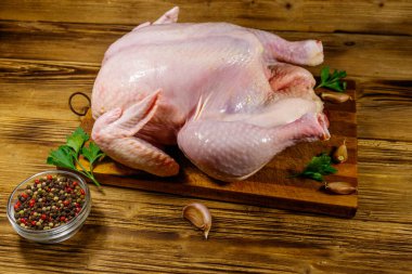 Ahşap bir masada baharatlı bütün tavuk.