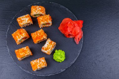 Suşi Philadelphia 'yı siyah bir levhada yuvarlıyor. Üst görünüm