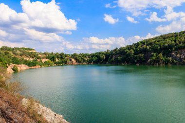 Yazın terk edilmiş taş ocağında göl manzarası