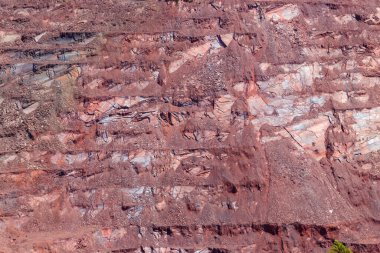 Demir cevheri ocağındaki kırmızı madencilik seviyelerine yakın çekim. Benimkini aç, ocağı aç. Arkaplan, doku