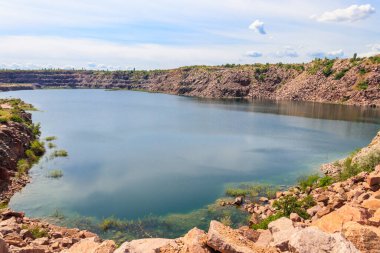 Yazın terk edilmiş taş ocağında göl manzarası