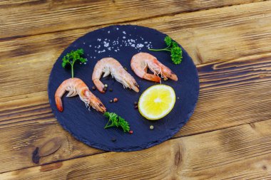 Tahta tahtada limonlu, maydanozlu, tuzlu ve biberli büyük çiğ karidesler