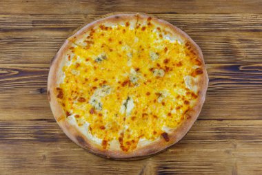 Tahta arka planda dört peynirli pizza. Üst görünüm