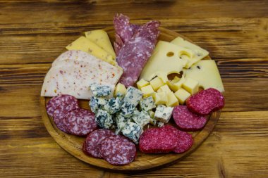 Tahta masada İtalyan salam ve peynirinden oluşan antipasti tabağı.