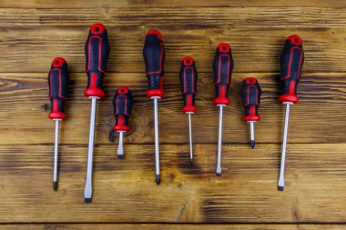 Tahta arka planda bir tornavida seti. Üst görünüm