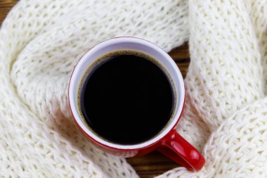Etrafında beyaz örülü eşarp olan bir fincan kahve. Üst Manzara. Kış konsepti
