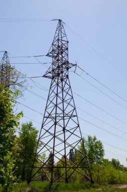 Mavi gökyüzüne karşı yüksek voltajlı güç hattı