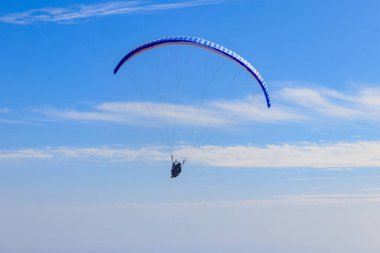 Mavi gökyüzündeki paraşütçüler. Aktif yaşam tarzı ve ekstrem spor macerası kavramı