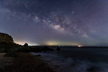 Deniz kenarındaki yıldızlı gökyüzü ve Samanyolu
