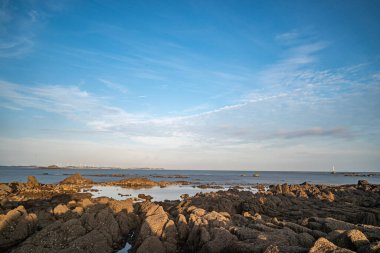 Mavi gökyüzünün altında sarı resif ve deniz