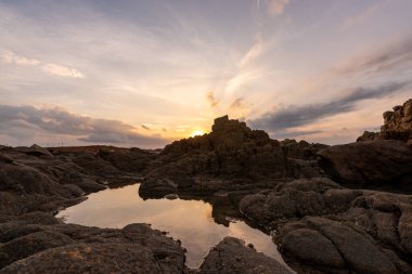 Akşamları, deniz kayaları tokatladı.