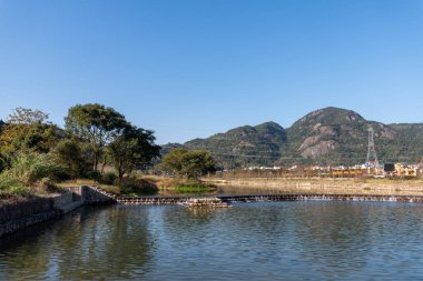 Taşra nehri dağı yansıtıyor, ve köyler ve ormanlar mavi gökyüzünün altında.