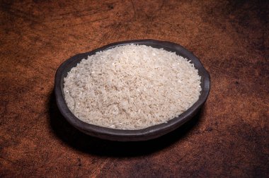 Kasedeki beyaz pirinç koyu arkaplanda.