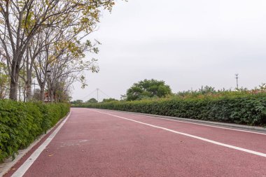 Bulutlu bir günde, parkta kırmızı asfalt pist