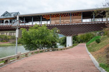 Nehirde bir köprü ve köprünün altında kırmızı bir pist var.